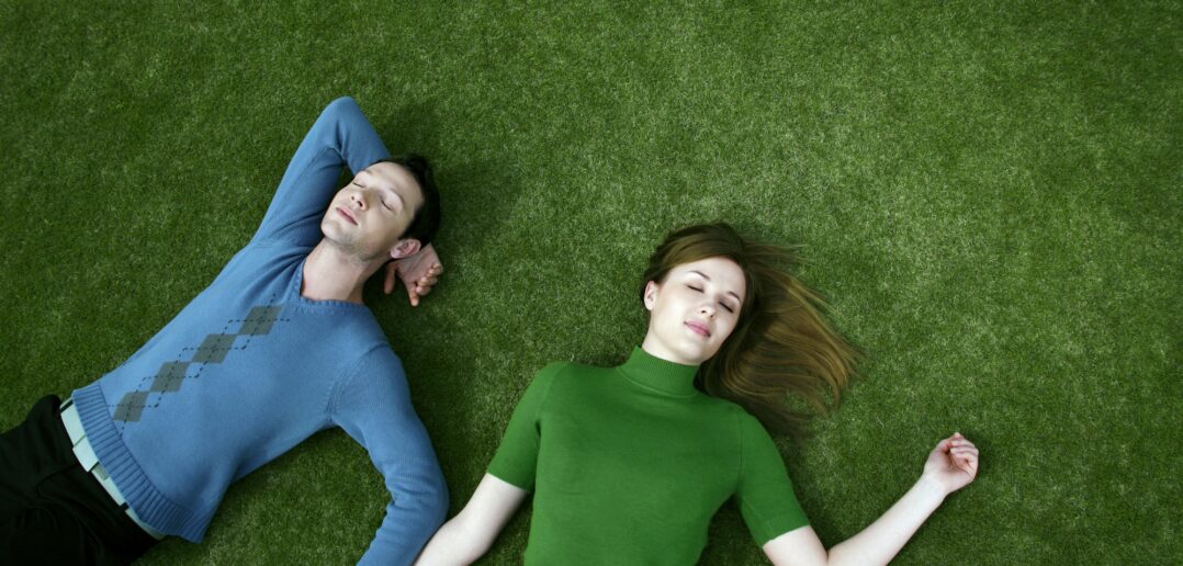 Par ligger på en græsplæne
